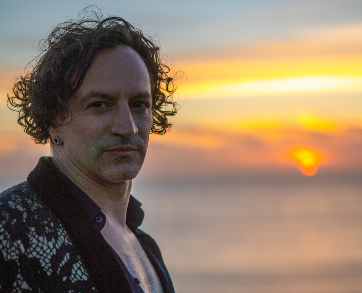 Destin Gerek, certified sexologist and men's sexuality coach, photographed at sunset by the ocean